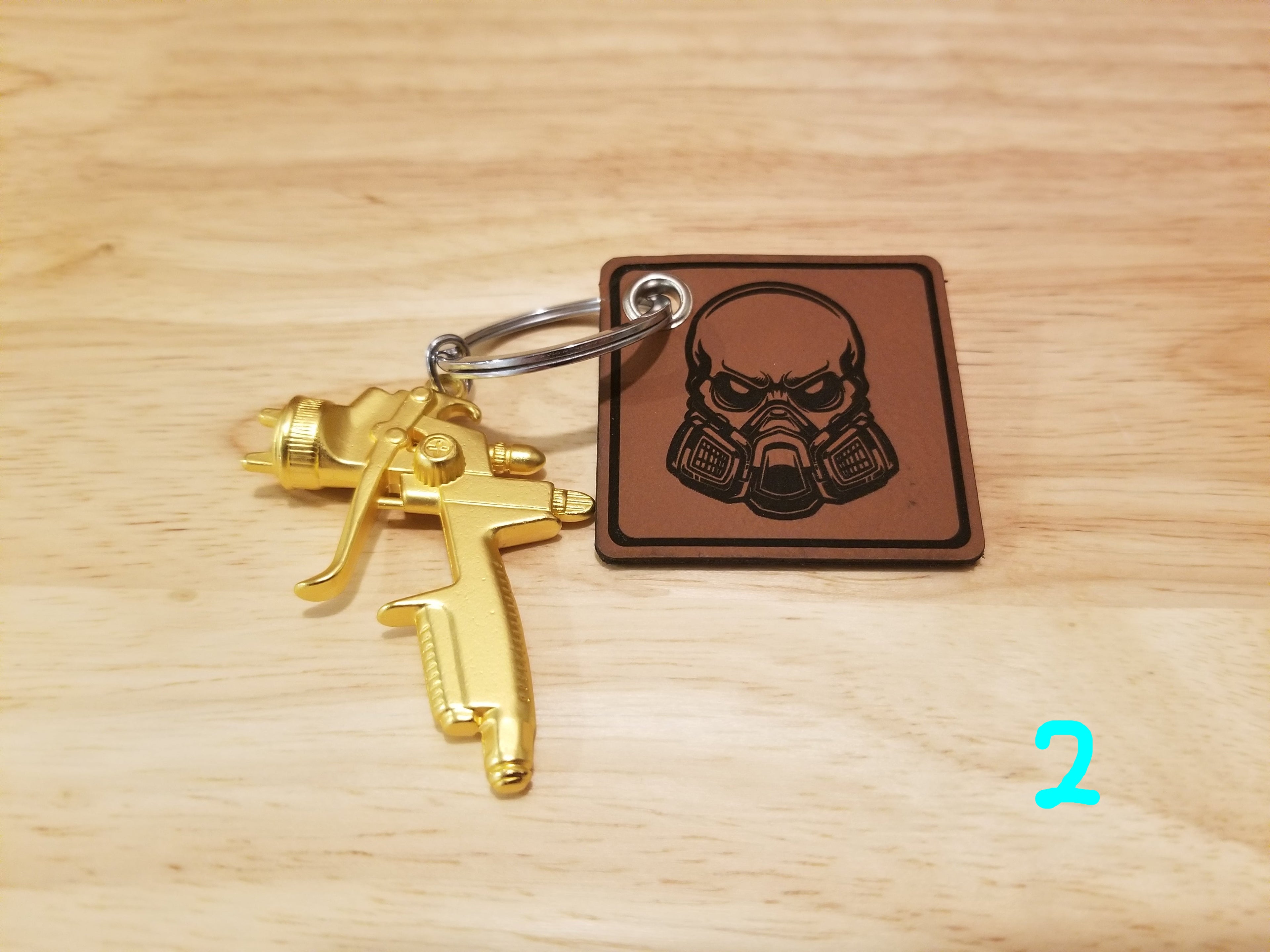 Body Shop Merch branded rawhide patch with Gold paint gun Keychain