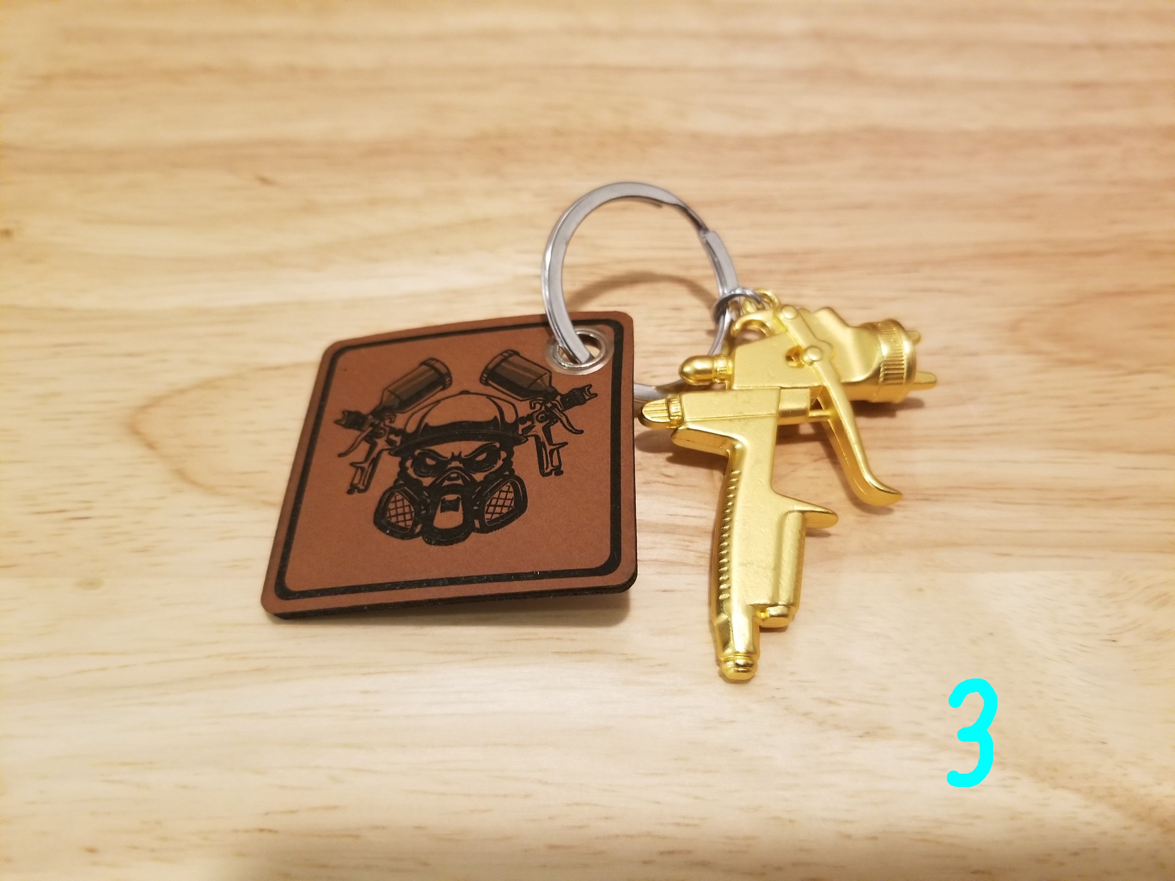 Body Shop Merch branded rawhide patch with Gold paint gun Keychain