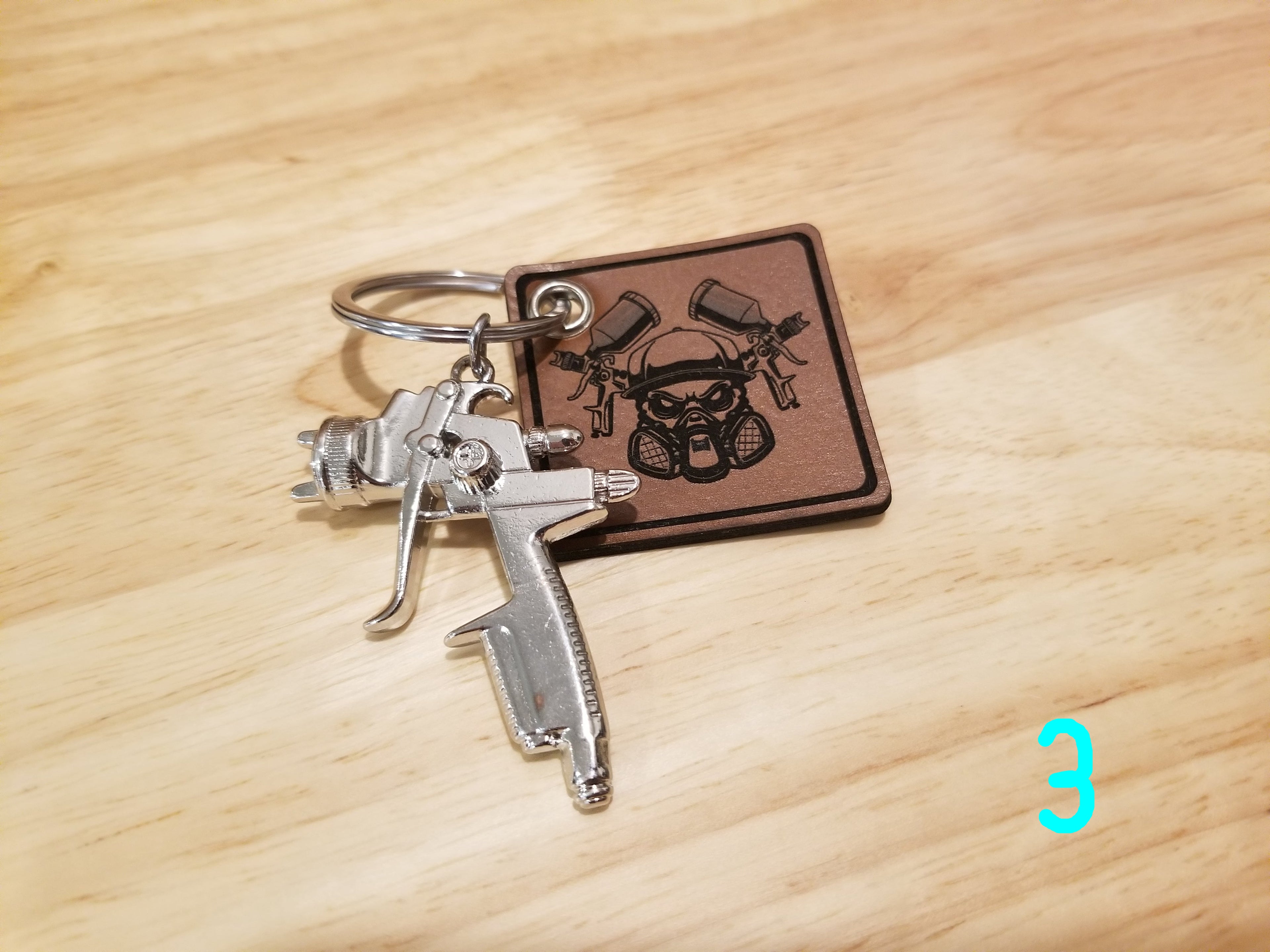 Body Shop Merch branded rawhide patch with Silver paint gun Keychain